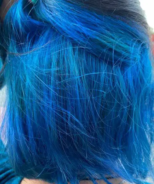 Mujer con el pelo de color azul brillante con reflejos luminosos