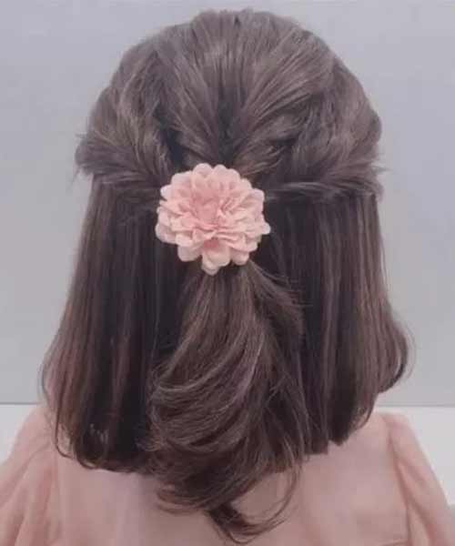 Peinado para niña con trenza en semi recogido y flor decorativa