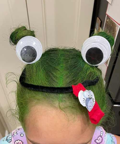 Peinado de niña con forma de rana verde y ojos saltones