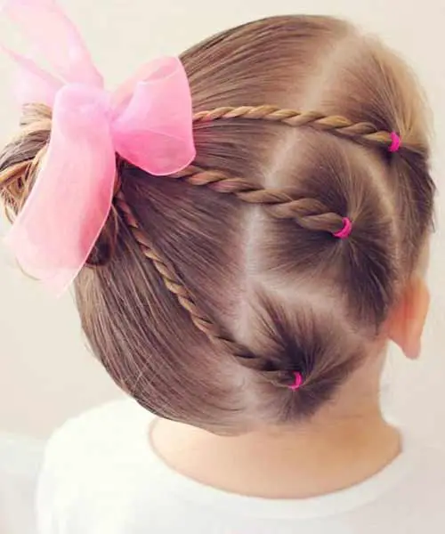 Peinado infantil con un recogido y un lazo rosa