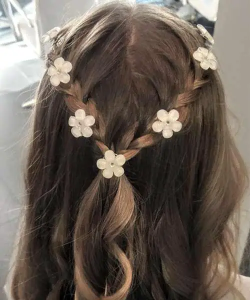 Bonito peinado de fiesta para niñas con dos trenzas y flores secas en el cabello