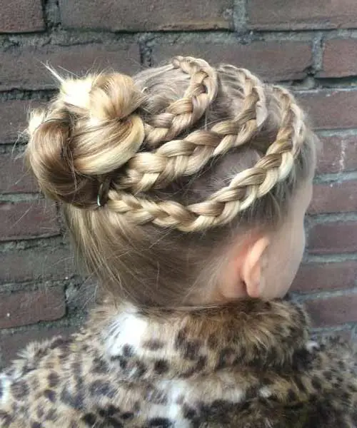 Peinado elegante para niña con tres trenzas unidas en un moño alto