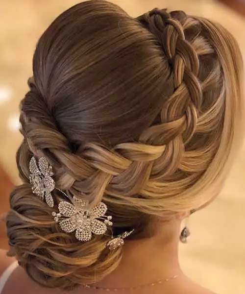 Peinado recogido para bodas con trenzas y accesorios de flores en el pelo