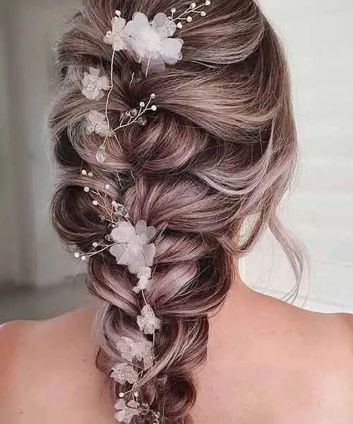 Peinado de boda con una trenza y flores blancas