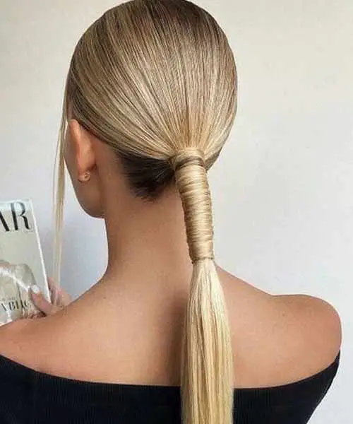 Peinado creativo con coleta y pelo liso con un mechón de pelo rodeando el recogido