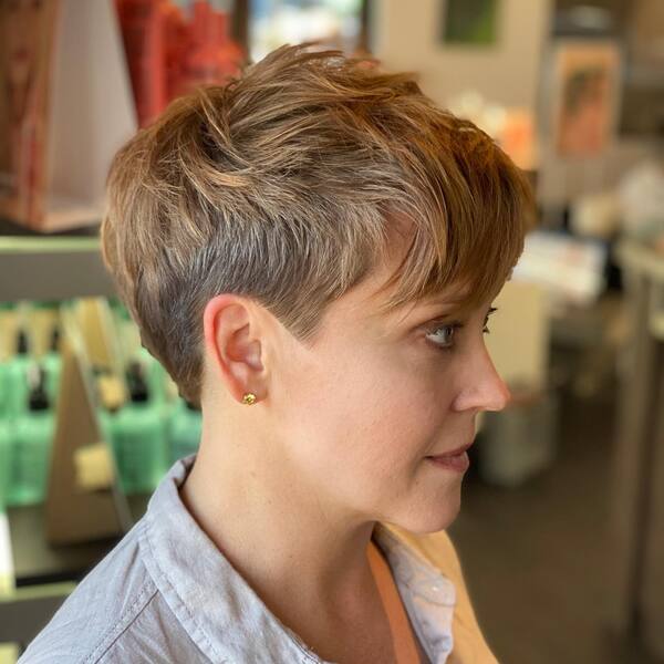 Edgy Pixie Cut with Side Bangs: una mujer con aretes de oro