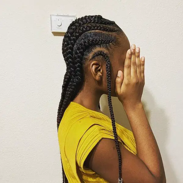 trenzas Cornrows: una mujer con un vestido entero de color amarillo