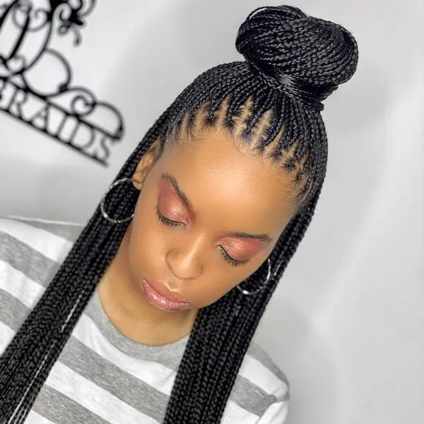 Ghana Braids: una mujer con maquillaje completo y aretes de plata.