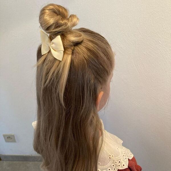 Messy Half Hair Bun Peinados para niñas: una niña con un vestido de islote.