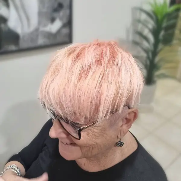 Peachy Blonde Pixie Cut: una anciana con anteojos y una camisa negra