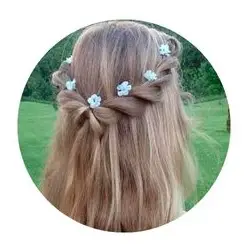 Peinado sencillo para niña con semi recogido y flores decorativas