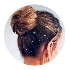 Peinado de mujer festivo con moño alto y brillos adhesivos en el pelo