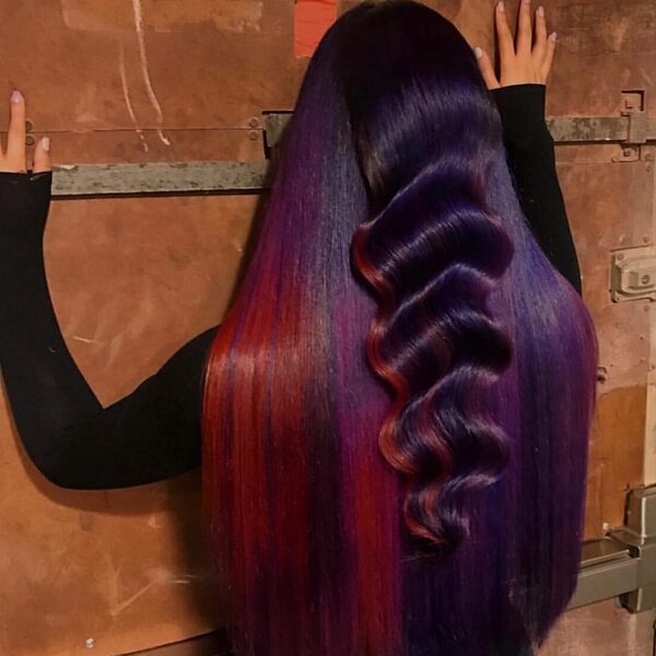 cabello rojo púrpura - una mujer con manga larga negra, tocando la pared