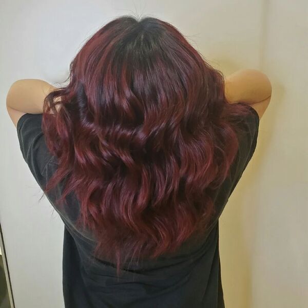 cabello rojo oscuro - una chica levantando su cabello usando una camisa negra