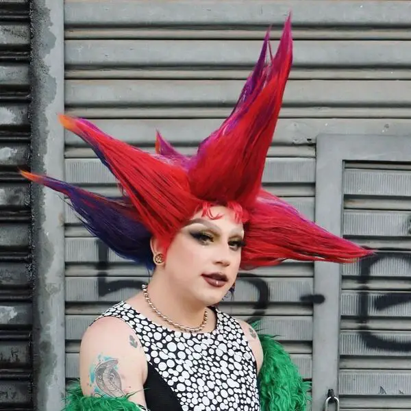 Crazy Big Punk Hairstyle: una mujer con un tatuaje que lleva una blusa estampada negra