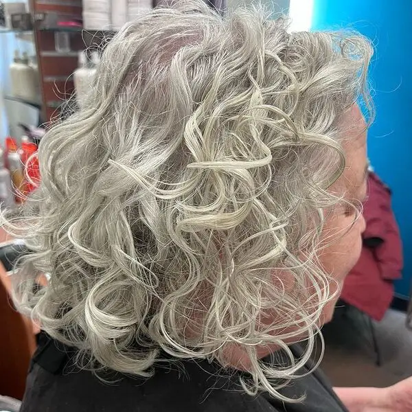 Swirly Curl Silver Hair: una anciana con una capa negra