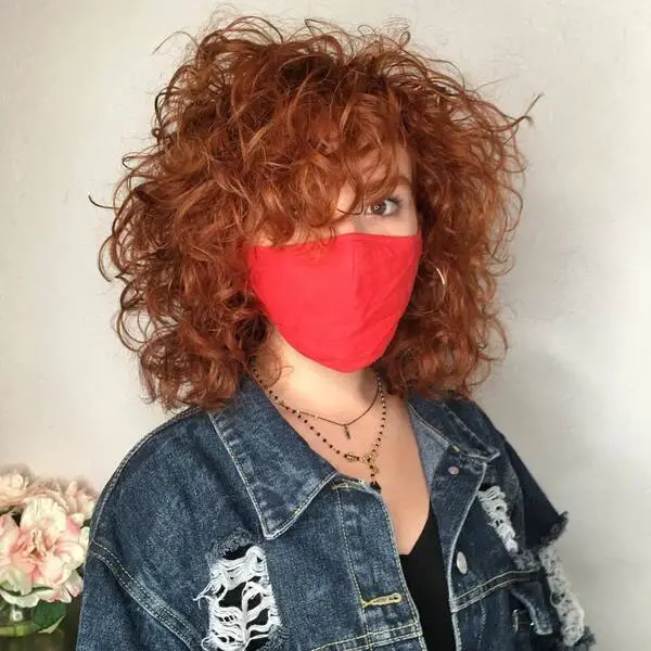 Peinado de los 90: una mujer con mascarilla roja y una chaqueta de mezclilla azul