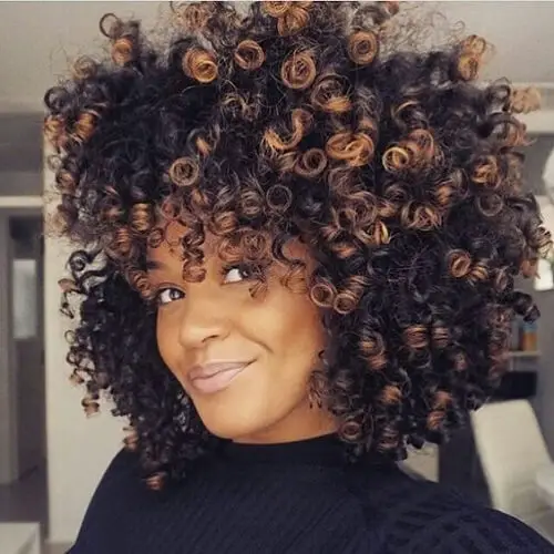 cabello afro natural con balayage cobre