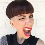 a woman with bowl cut with mouth wide open