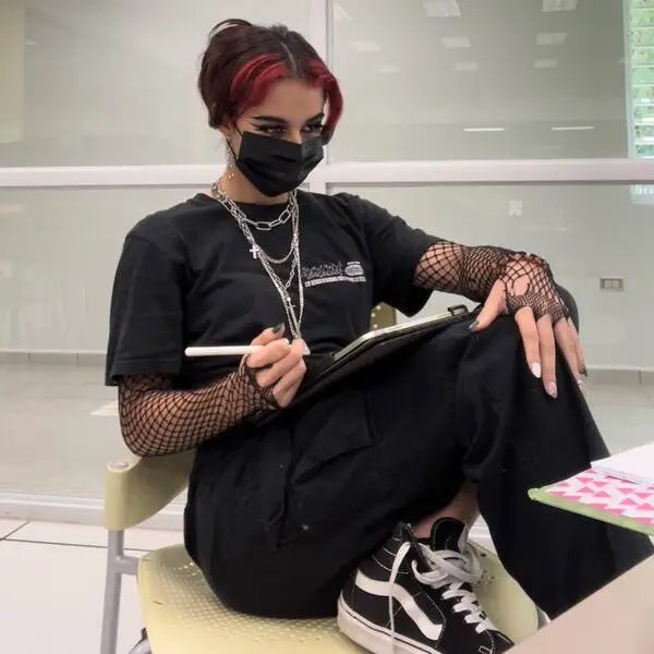 cabello egirl: una niña sentada en una silla y tiene una red de pesca en sus manos, usa una máscara facial y una camisa negra y pantalones cargo