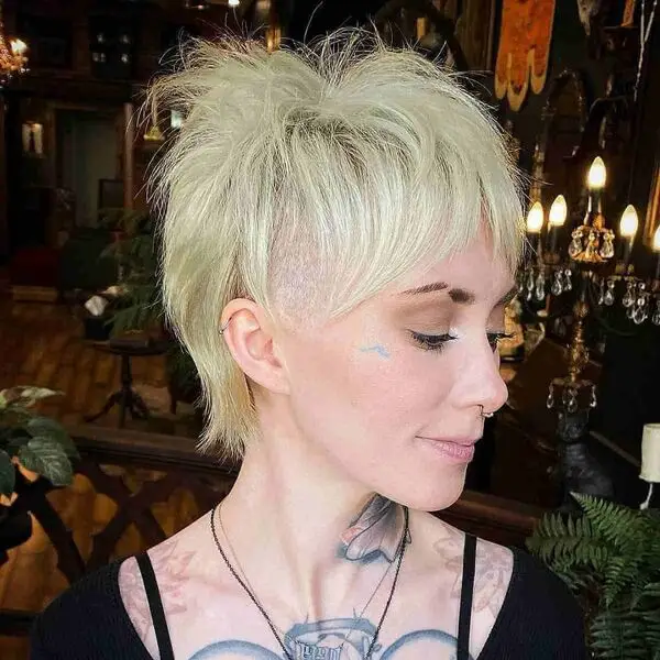 Longer Pixie: una mujer con un tatuaje que lleva una camisa negra