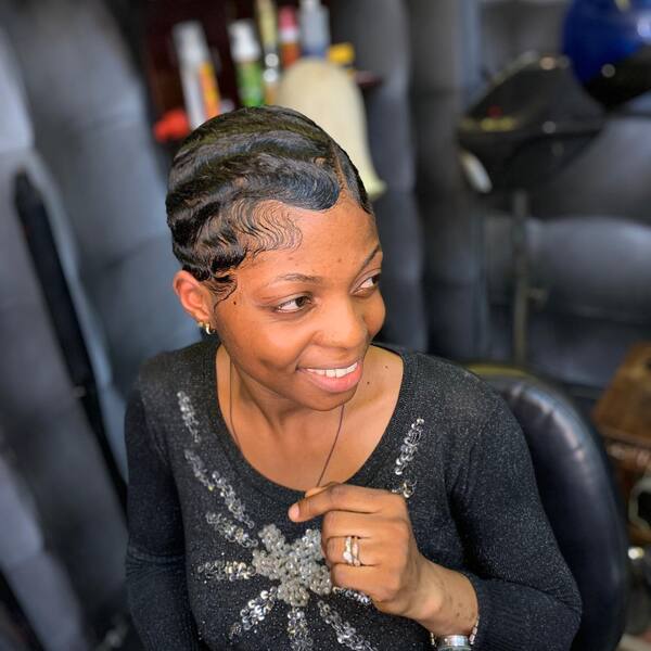 Ondas de los dedos en el cabello afroamericano: una mujer con una manga larga negra