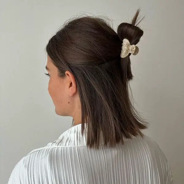 una mujer con una pinza para el pelo con una blusa blanca