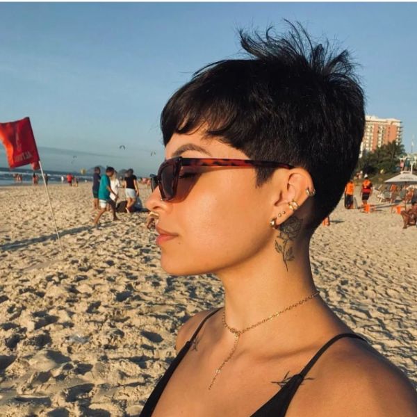 mujer con gafas de sol en una playa de arena blanca