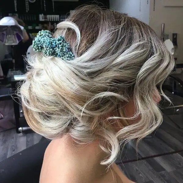 Messy Blonde Bun Bride Hairstyle: una mujer con accesorios para el cabello