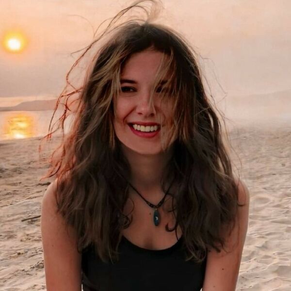 Millie Bobby Brown - sonriendo y está en una playa