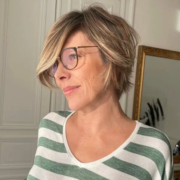 una mujer con anteojos vistiendo una blusa a rayas