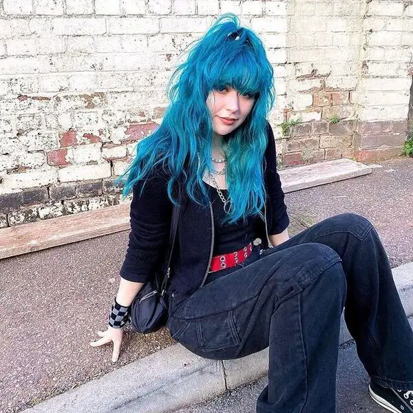 egirl hair - una chica sentada en el cemento y vestida de negro