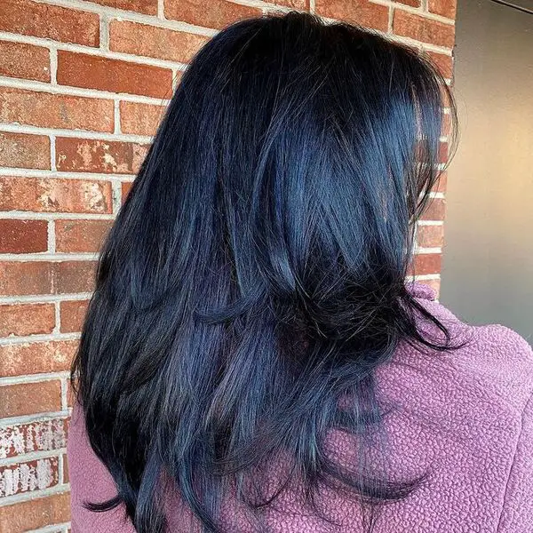 Shag Cut with Blue Black Hair: una mujer con un abrigo rosa de piel