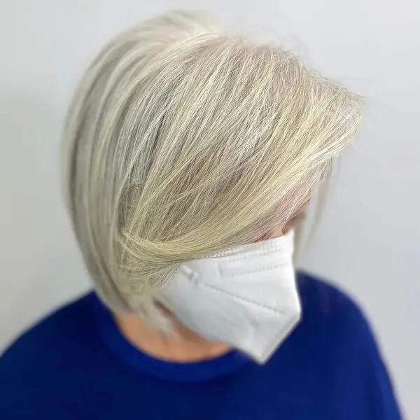 Silver Bob Hairstyle: una mujer con una máscara facial azul oscuro y blanca