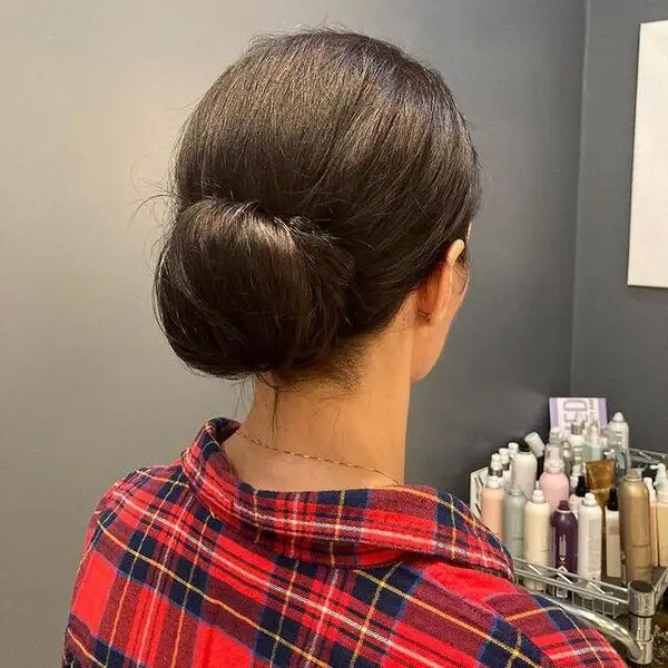 una mujer con collar con una manga larga a cuadros en sus peinados profesionales