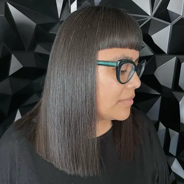 Corte de pelo recto y elegante: una mujer con anteojos