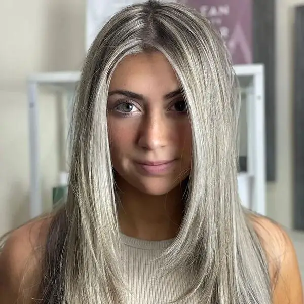una mujer de cabello plateado con un top gris