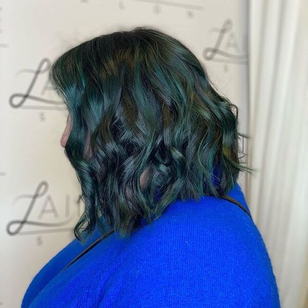 una mujer que lleva una manga larga de punto azul tiene un color de pelo azul verdoso