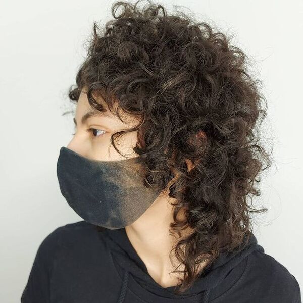 Volume Curls Mullet: una mujer con una chaqueta negra con capucha y una máscara.